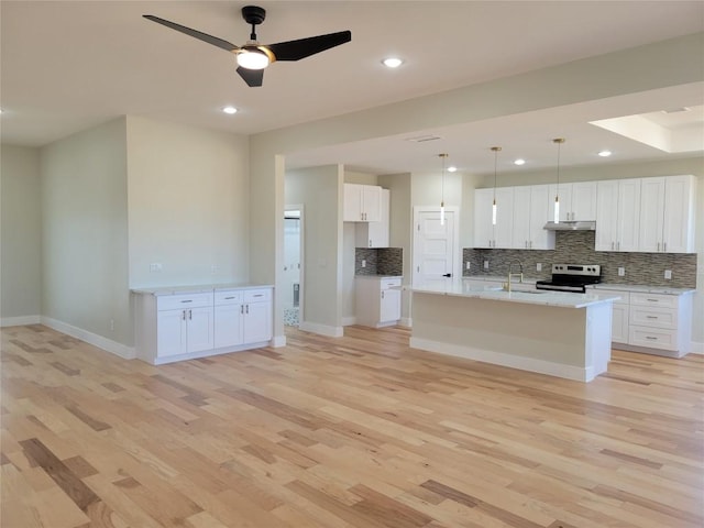 kitchen featuring a kitchen island with sink, tasteful backsplash, white cabinets, stainless steel range with electric cooktop, and light wood-type flooring