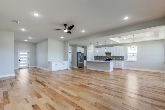 unfurnished living room with visible vents, recessed lighting, light wood finished floors, and baseboards