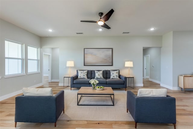 living room with baseboards, ceiling fan, light wood-style flooring, and visible vents