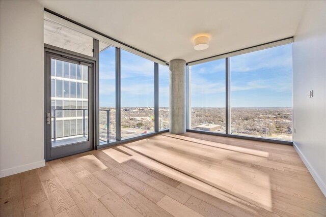 44 E Ave Unit 1407, Austin, TX 78701 - empty room with floor to ceiling windows, wood finished floors, and baseboards