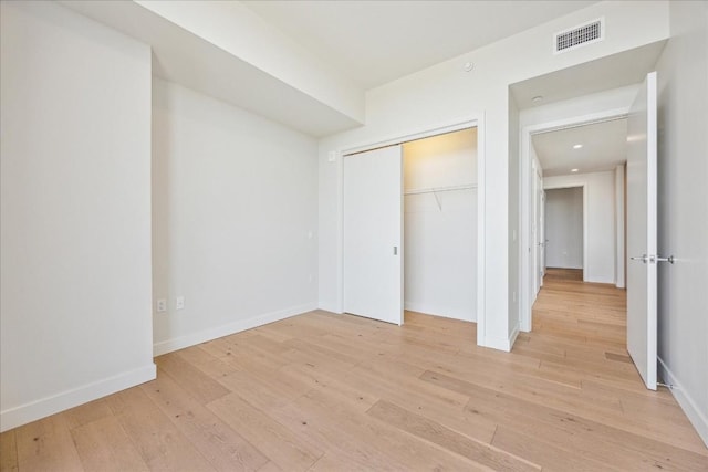 unfurnished bedroom featuring a closet and light hardwood / wood-style flooring