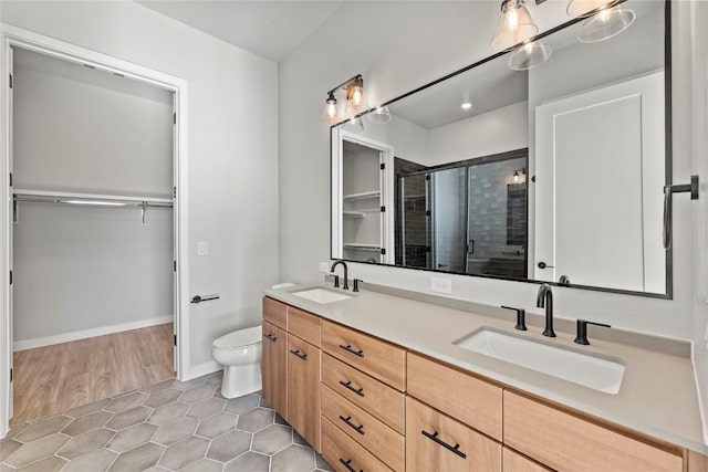 bathroom featuring vanity, toilet, a shower with shower door, and tile patterned flooring