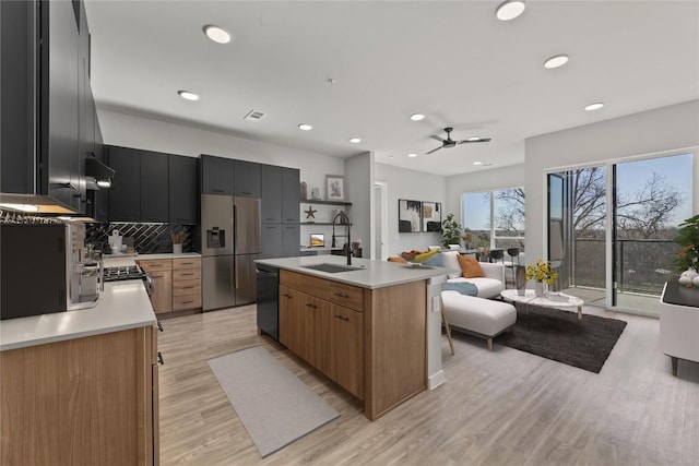 kitchen featuring tasteful backsplash, black dishwasher, sink, a kitchen island with sink, and stainless steel refrigerator with ice dispenser