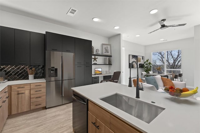 kitchen featuring tasteful backsplash, dishwasher, sink, light hardwood / wood-style floors, and stainless steel fridge with ice dispenser