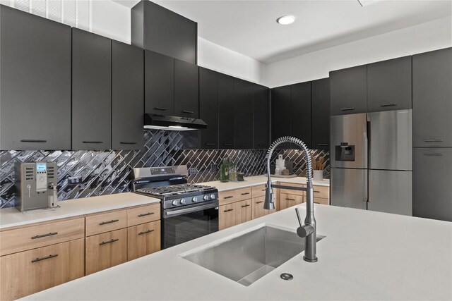 kitchen with tasteful backsplash, stainless steel appliances, light brown cabinetry, and sink