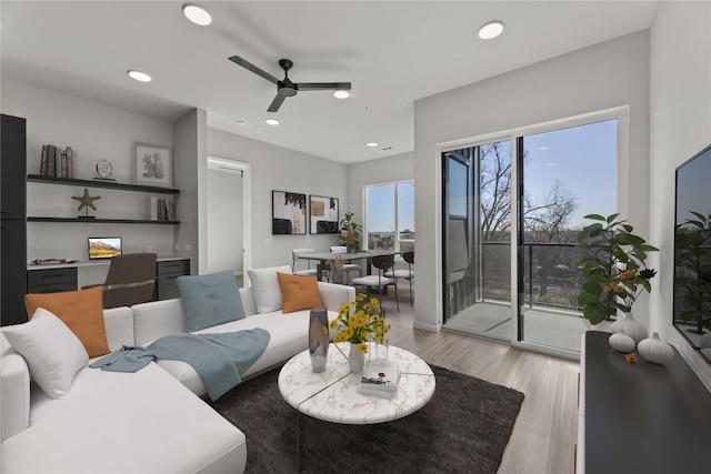 living room featuring ceiling fan and light wood-type flooring