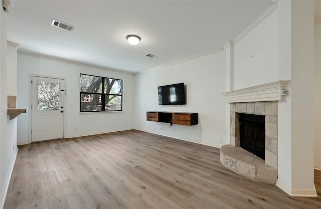 unfurnished living room with ornamental molding and light wood-type flooring