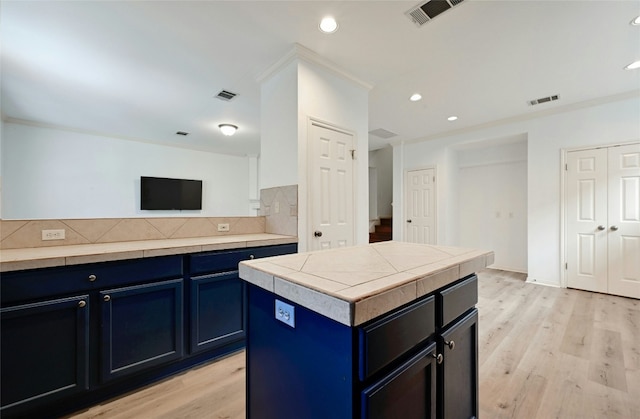 kitchen with light wood-type flooring, blue cabinetry, and a kitchen island