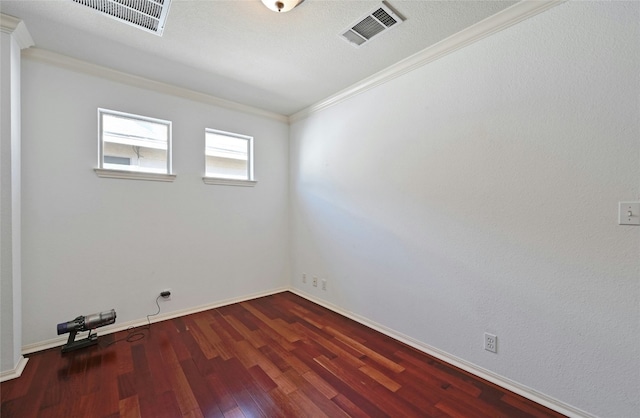 spare room featuring crown molding and dark wood-type flooring