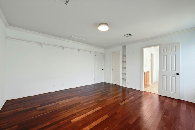 spare room featuring ornamental molding, hardwood / wood-style floors, and built in features