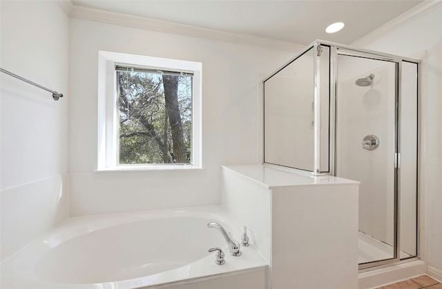 bathroom with ornamental molding and separate shower and tub