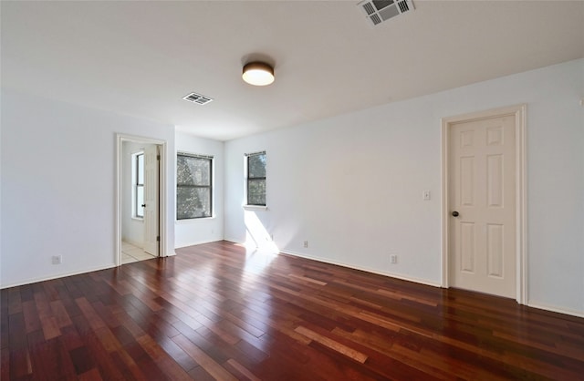 empty room with dark hardwood / wood-style flooring