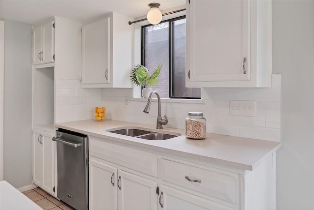 kitchen with white cabinetry, decorative backsplash, and a sink