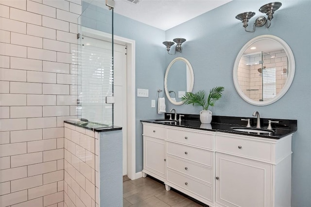 full bath featuring a walk in shower, double vanity, and a sink