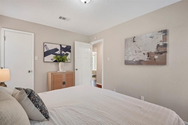 bedroom featuring a textured ceiling and visible vents