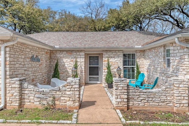 property entrance with stone siding and roof with shingles