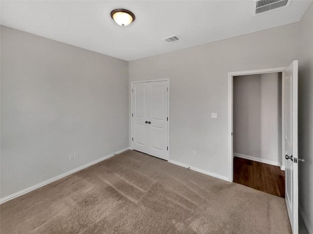 unfurnished bedroom with carpet floors and a closet