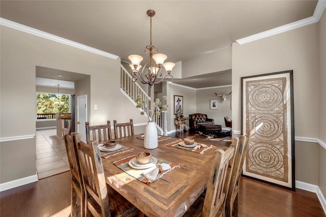 dining area featuring an inviting chandelier, hardwood / wood-style floors, and crown molding