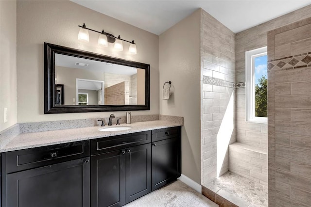 bathroom featuring vanity and tiled shower