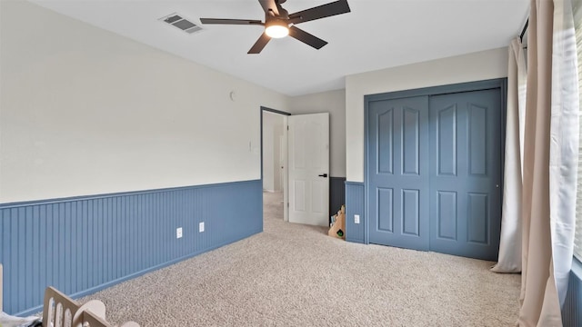 31108 La Quinta Dr, Georgetown, TX 78628 - unfurnished bedroom featuring a closet, carpet, a ceiling fan, and wainscoting
