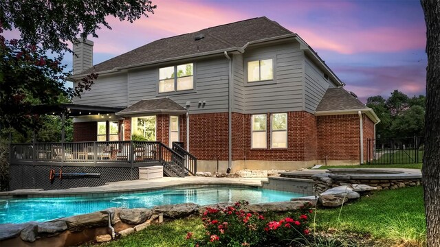 31108 La Quinta Dr, Georgetown, TX 78628 - rear view of house with a deck, a chimney, brick siding, and roof with shingles
