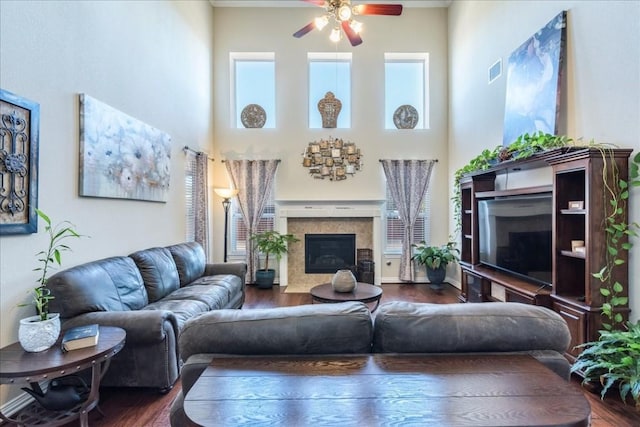 living room with ceiling fan, plenty of natural light, dark hardwood / wood-style flooring, and a high ceiling