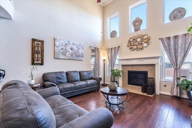 living room featuring a tiled fireplace and dark wood-type flooring