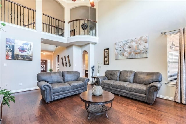 living room featuring hardwood / wood-style floors, a towering ceiling, and plenty of natural light