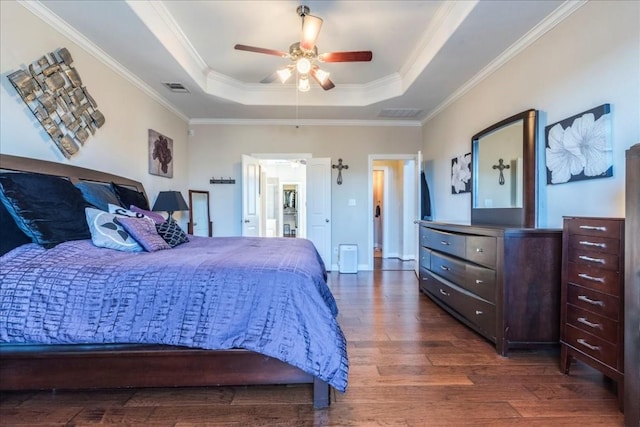 bedroom featuring crown molding, ceiling fan, dark hardwood / wood-style flooring, and a raised ceiling