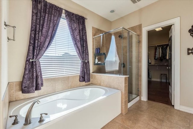 bathroom featuring a healthy amount of sunlight, independent shower and bath, and tile patterned flooring