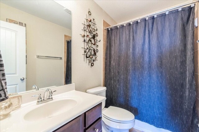 bathroom with vanity, toilet, and walk in shower