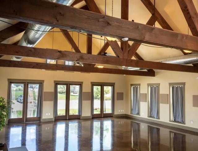 interior space featuring beamed ceiling and a towering ceiling