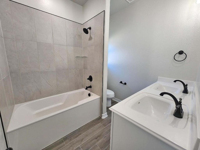 full bathroom with tiled shower / bath combo, vanity, and toilet