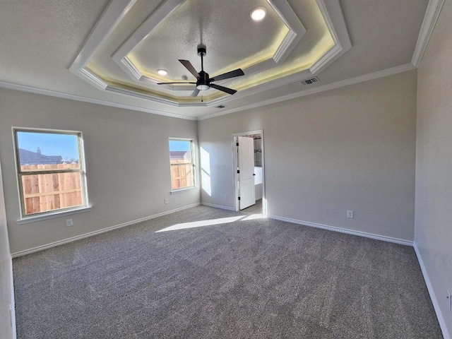 spare room featuring a tray ceiling, ornamental molding, ceiling fan, and carpet flooring