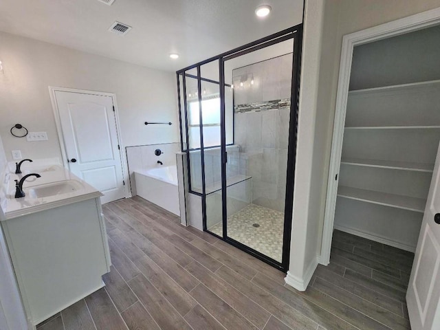 bathroom featuring vanity and independent shower and bath