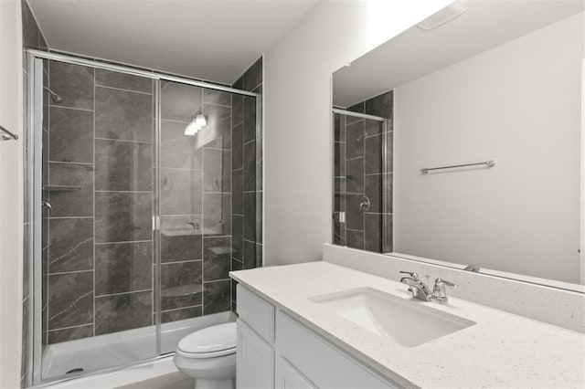 bathroom featuring vanity, an enclosed shower, and toilet