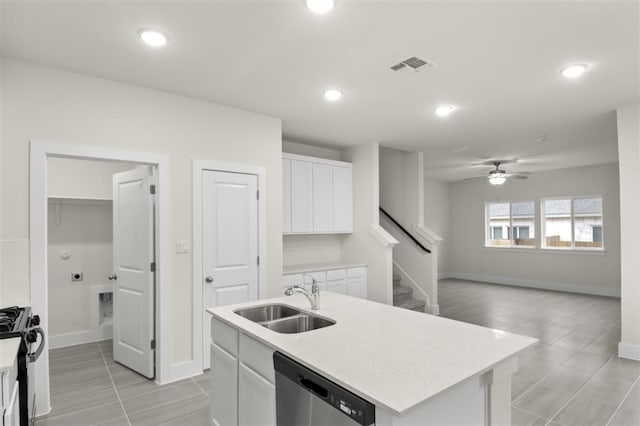 kitchen featuring gas stove, sink, dishwasher, an island with sink, and white cabinets