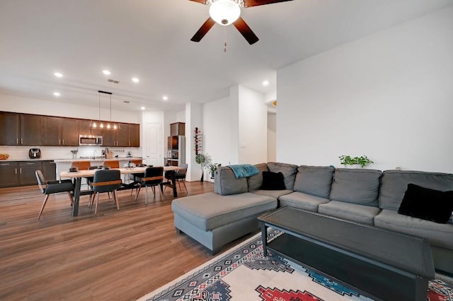 living room featuring ceiling fan and hardwood / wood-style floors