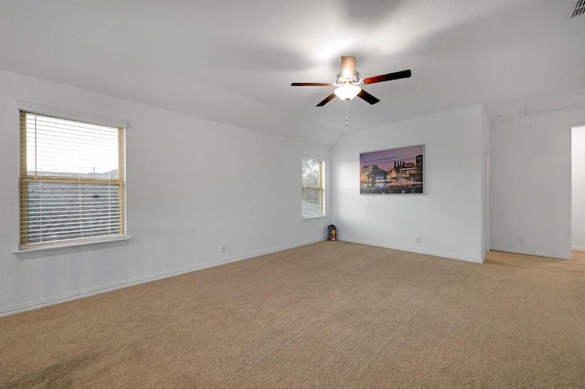 carpeted spare room with ceiling fan and vaulted ceiling