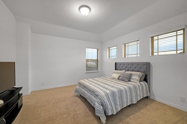 bedroom with light colored carpet and a textured ceiling