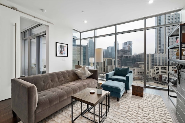 living room with a healthy amount of sunlight, a wall of windows, and light wood-type flooring