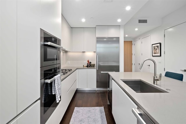 kitchen featuring white cabinetry, sink, dark hardwood / wood-style floors, and appliances with stainless steel finishes