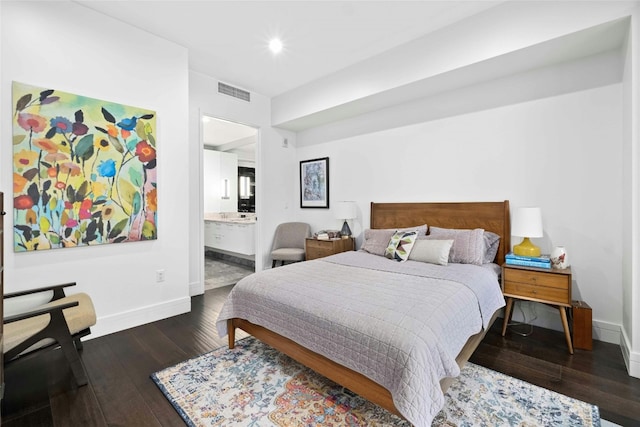 bedroom with connected bathroom and dark hardwood / wood-style flooring