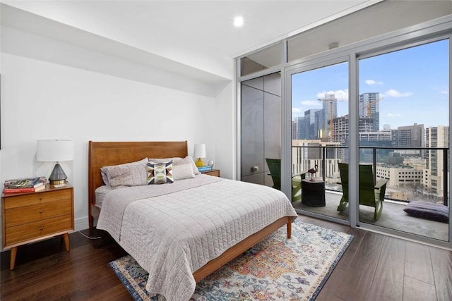 bedroom featuring access to exterior, dark hardwood / wood-style floors, and expansive windows