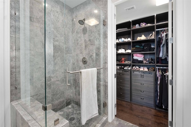 bathroom with wood-type flooring and a shower with door