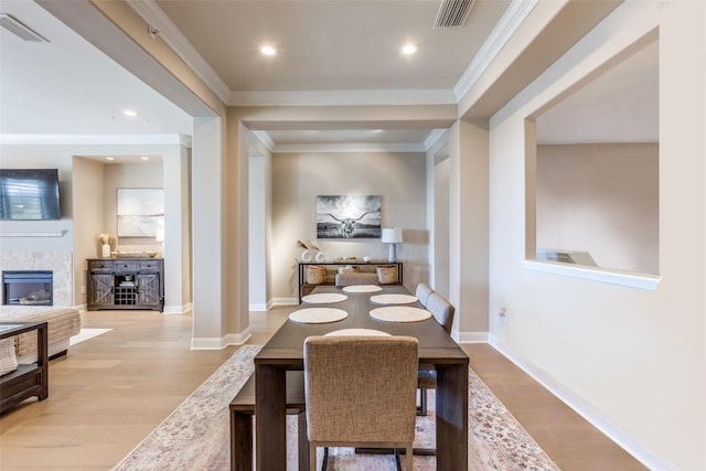 dining area featuring crown molding and light hardwood / wood-style flooring