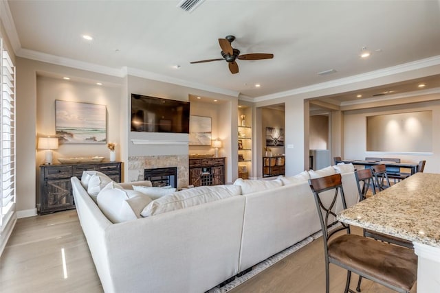 living room with crown molding, ceiling fan, and light hardwood / wood-style flooring