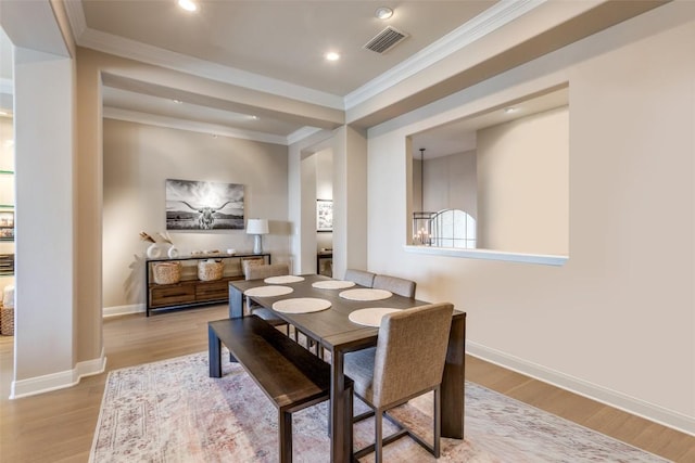 dining space featuring crown molding and light wood-type flooring