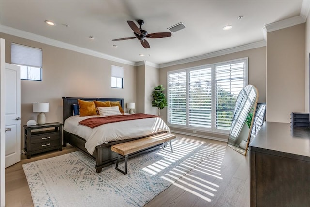 bedroom with ornamental molding, ceiling fan, and light hardwood / wood-style flooring