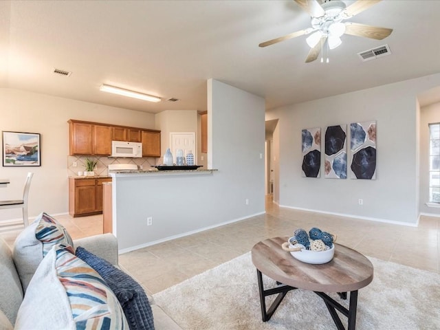 living room featuring light tile patterned floors and ceiling fan